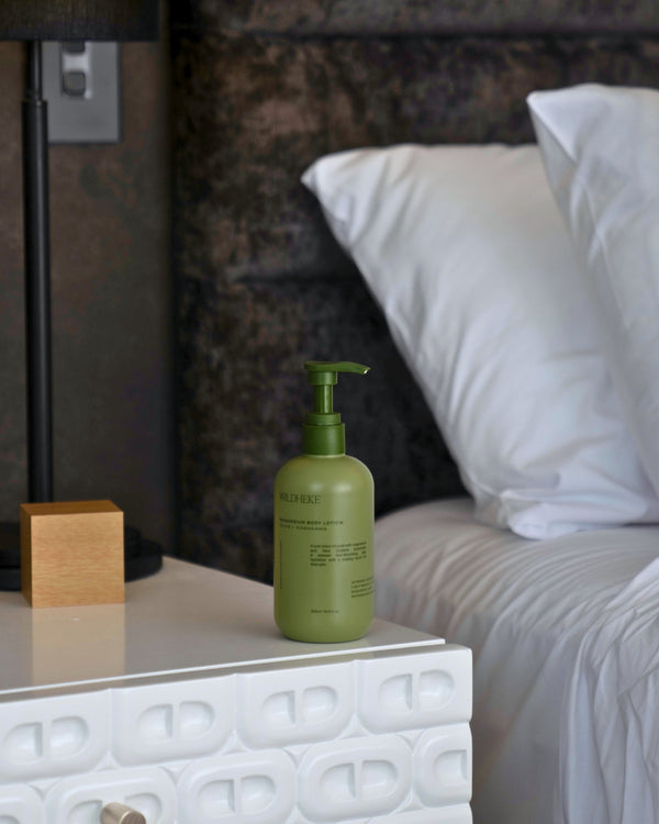 Wildheke body lotion in a calm bedroom setting for everyday skin care